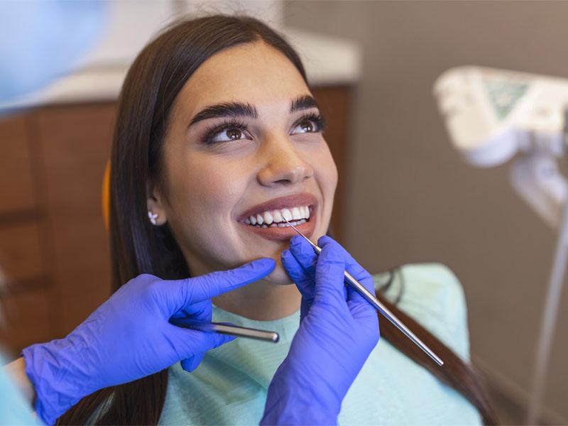 Woman sitting in a dentist chair with employee benefits in Huntington, WV