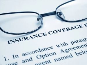 A pair of eye glasses sitting on an insurance coverage document